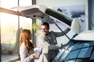 Couple checking the trunk space of a new car at a dealership