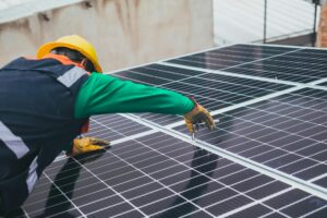 Technician installing solar panels on a roof