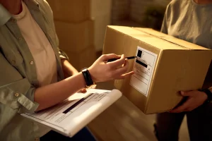 Two delivery workers checking parcel data in the office