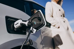 Woman charging her electric car in front of her house