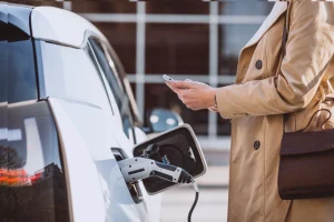 Woman charging her electric car at a charging point