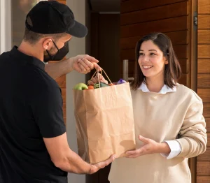 Courier handing a customer a bag of groceries